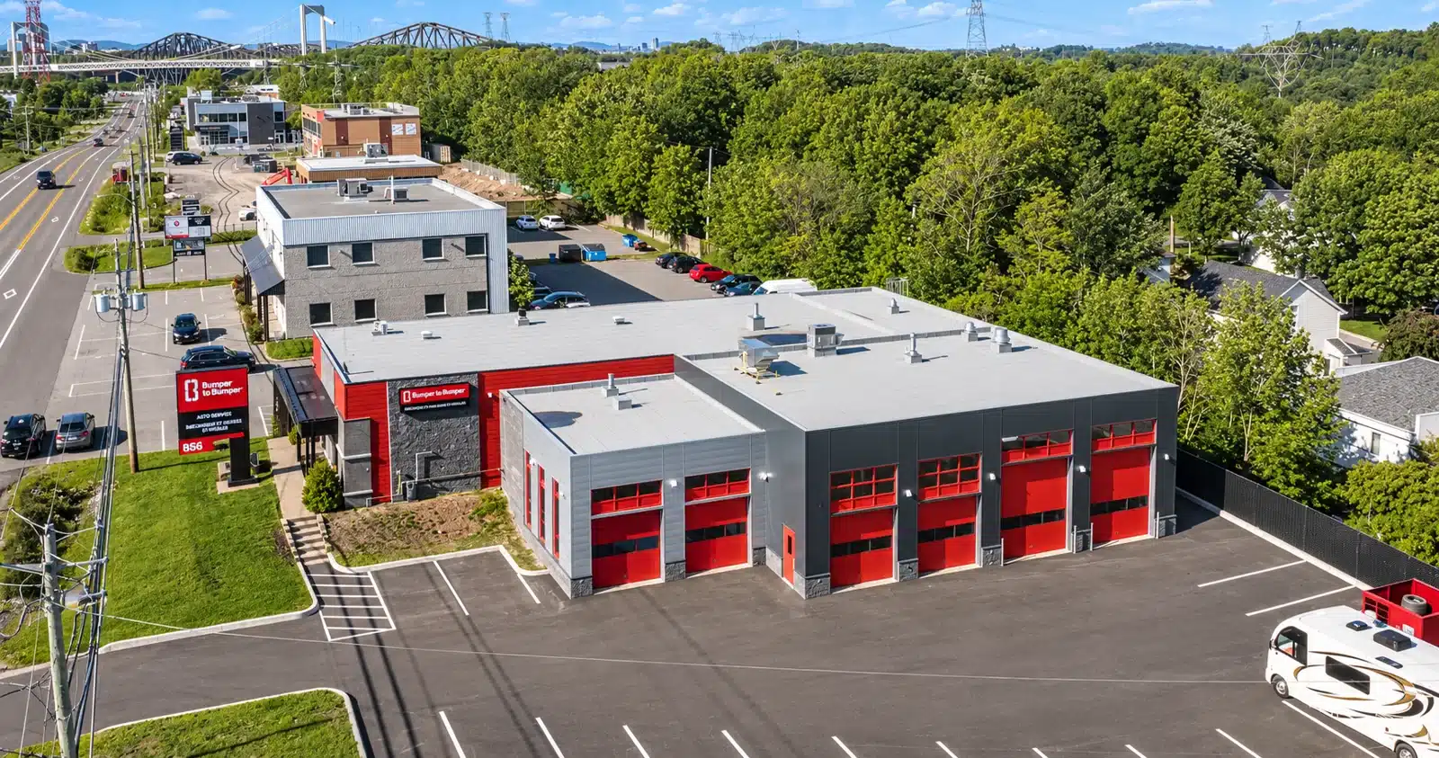 Bâtiment industriel à portes de garage rouges réalisé par Constructions M, vue aérienne